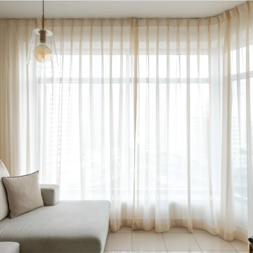 Sheer curtains hanging from a rod in a modern living room