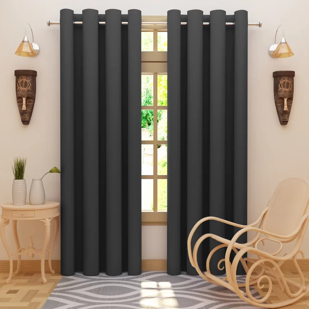 Room with black grommet curtains on a window, flanked by two tribal masks and wall sconces
