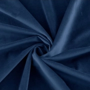 A swirling, close-up shot of rich, dark blue velvet fabric, emphasizing its soft texture and slight sheen.