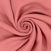Elegant swirl of plain, solid Coral blackout curtain fabric, displaying a beautiful light pink-orange hue.