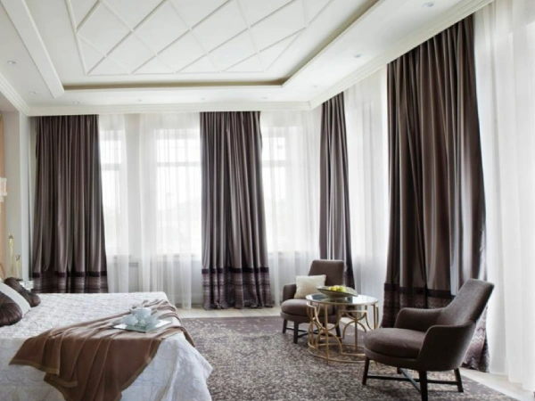 Floor-to-ceiling sheer and Bold Patterns Blackout curtains are hang in luxury bedroom in Dubai