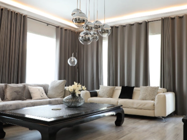 Luxurious gray suede blackout curtains hang across a bright, modern living room in Dubai.
