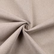 Matte, woven Beige blackout fabric with a fine texture, draped and twisted to show the material's thickness.