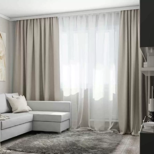 _Minimalist living room with a gray sectional, shag rug, and layered linen curtains over a window.