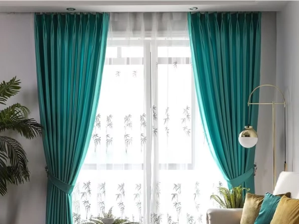Vibrant teal jacquard blackout curtains in a Dubai living room with a chic sofa and glass table.