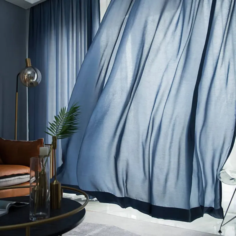 Flowing navy blue Curtains add a modern touch to a cozy living room with elegant gold accents.
