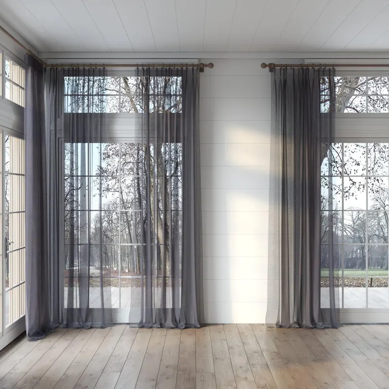 Grey & Charcoal sheer Curtains hang over large windows in a bright, airy room with wood floors.