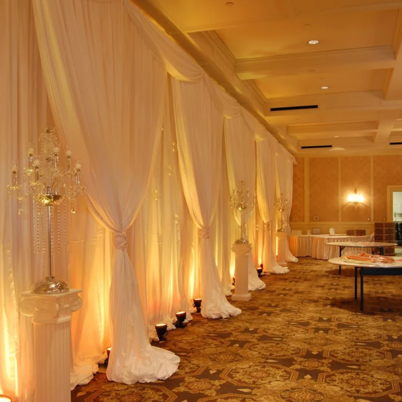 Best white backdrops with warm uplighting curtains and crystal candelabras for a luxury event.