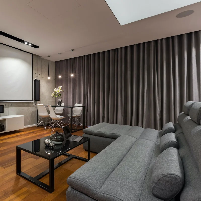 Elegant motorized curtains in a home theater, providing automated blackout for a cinema experience.