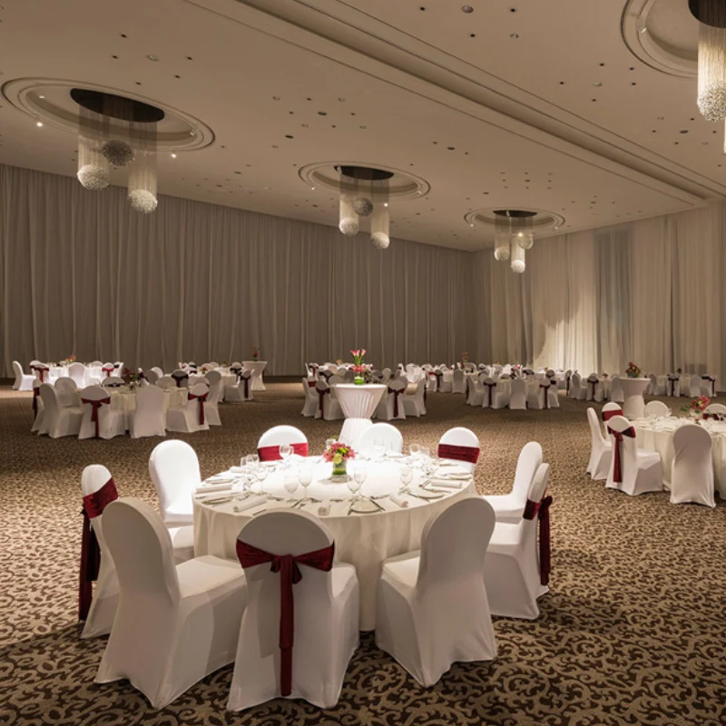 Elegant white ballroom curtains in a luxury Dubai venue, featuring grand chandeliers and banquet.