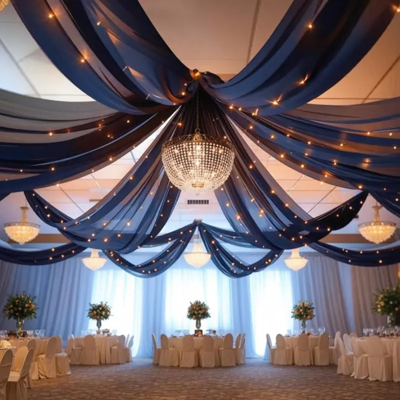 Modern ballroom featuring navy blue ceiling drapes, crystal chandeliers, and white table settings.