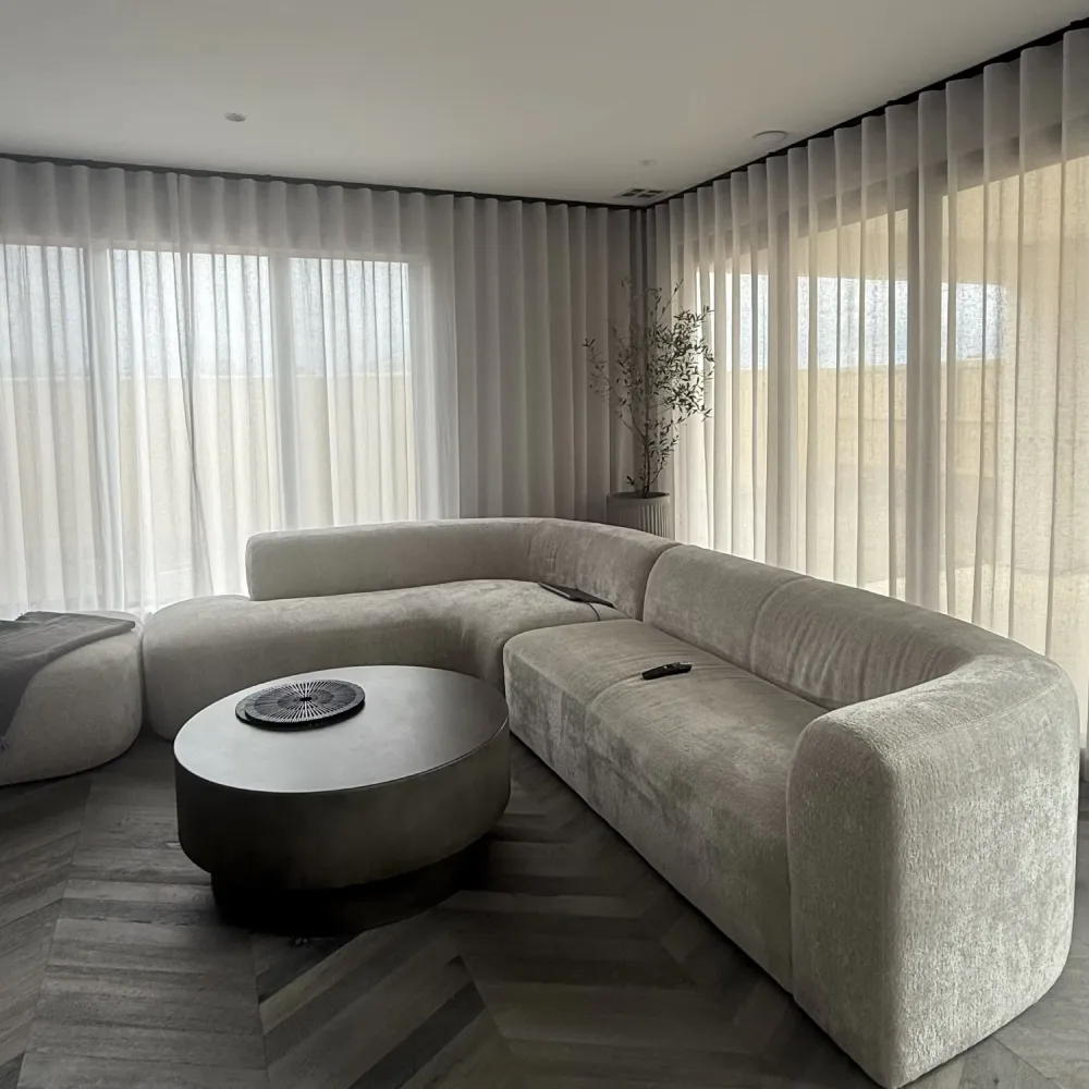 Ripple Fold sheer curtains with gentle drapes enhancing a cozy living room ambience.